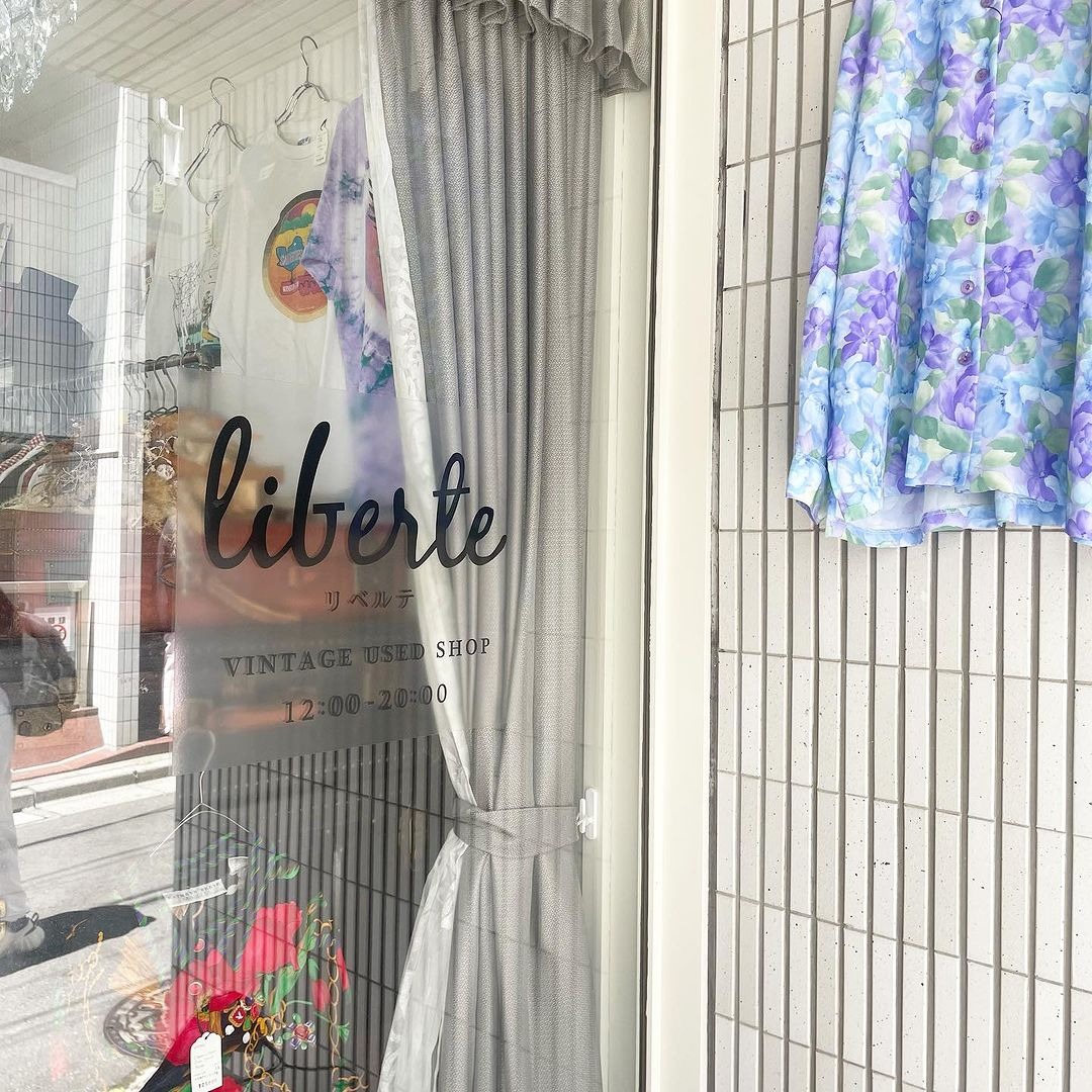 liberteの店名が見えるガラスの入口と店頭の服